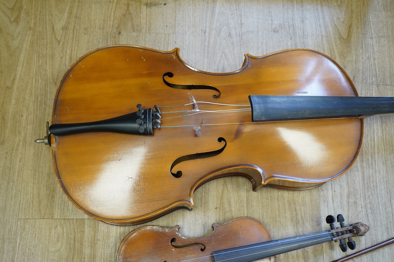 A student’s Golden Strad ‘cello imported by Boosey and Hawkes, body 69.5cm and violin, body 36cm, and a wooden conductors baton. Condition - poor to fair